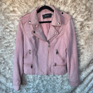 Rosa mockajacka från Vero Moda - Snygg rosa skinnjacka i mocka-look från Vero Moda med silvriga dragkedjor och detaljer. 