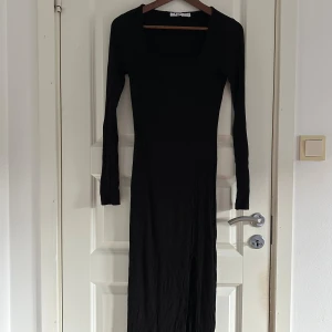 Svart ribbad långklänning NA-KD - Svart långklänning från NA-KD med fyrkantig ringning och lång ärm. Klänningen är ribbad, har en tight passform och en snygg slits på sidan. 🖤