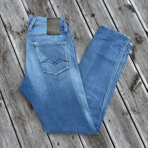 Replay Anbass Hyperflex jeans ljusblå - Säljer ett par Replay Anbass Hyperflex jeans i ljusblå tvätt. Slim fit-modell med klassiska fem fickor, snygga detaljer på bakfickorna och bekvämt stretchigt material. Perfekta för dig som gillar en modern och stilren look. Kom gärna med frågor/offer!✌️