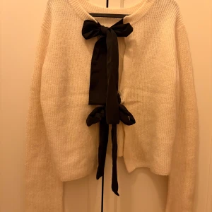 Vit kofta med svarta rosetter från Object NY - Ny med lappar kvar. Superfin stickad kofta från Object i vit nyans med två stora svarta rosetter framtill. Koftan har rund halsringning, lång ärm och är tillverkad i ullblandning. Perfekt för dig som vill ha en söt och trendig look med extra detalj. Nypris 599.