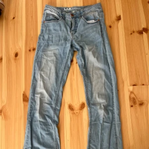 Ljusblå bootcut jeans från LAB Industries - Snygga ljusblå jeans från LAB Industries med klassisk femficksdesign och bootcut-ben. Jeansen har en normal passform och är tillverkade i mjukt denimtyg.