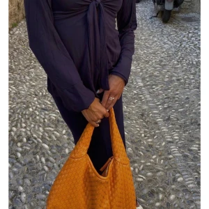 Marinblå blus från DesignbySi - Supersnygg lila långärmad topp från DesignSi med v-ringning och knyt framtill. Toppens material är mjukt och stretchigt.Passformen är normal och toppen har en stilren, enkel design som ändå sticker ut med knyt-detaljen, man kan ha tröjan bakåt fram vilket ger en fin öppen rygg!!♥️