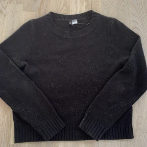 Svart stickad tröja från H&M Divided - Svart stickad tröja från H&M Divided i storlek XS. Tröjan har rund hals, ribbade muddar vid ärmslut och nederkant samt långärmad passform. Perfekt för dig som gillar enkel och stilren look med lite edge.