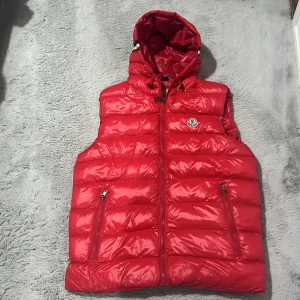 Röd dunväst  - Gammal röd väst lite sönder. 