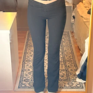 Svarta bootcut träningsbyxor  - Svarta bootcut träningsbyxor från H&M Move i stretchigt och mjukt SoftMove-material. Byxorna har låg midja med snygg omlott-detalj framtill och sitter tajt upptill med utsvängda ben. Perfekta för dig som gillar en sportig och trendig look.