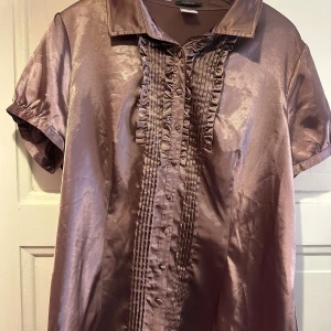 Champagnefärgad blus från La Redoute - Snygg champagnefärgad blus med glansig färg. Blusen har korta puffärmar, klassisk krage och dekorativa volanger samt knappar framtill. 