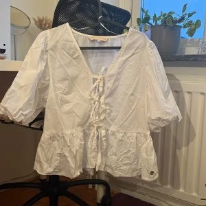 Blus - Säljer denna supersöta blusen med snörning. Ber om ursäkt för rynkorna och kommer defentivit att stryka den om försäljning blir aktuellt. Från Pernilla Wahlgrens avdelning på Ullared. Med puffärmar. Pris diskuterbart 🥰Endast använd 2 ggr. 