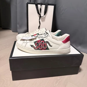 Gucci Ace Snake - Ett par gucci ace snake i us size 8. Dem passar storlek 42/43. Det är i bra skick! 7/10.  Säljs med box och dustbags. Dem är 100% autentiska finns kvitto samt Vinted verification. Kontakta mig gärna vid frågor och funderingar.
