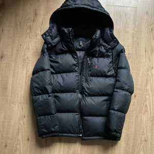 Ralph Lauren vinterjacka - Hej! Polo Ralph Lauren i nyskick. En varm, snygg och skön jacka nu till vintern. Säljer då jag har en annan. Avtagbar luva med knappar.  Storlek och passform: XL i barnstorlek vilket motsvarar S. Jag på bild är 180cm.  Qrkod som leder till RL hemsida (se sista bild) Om ni vill ha fler bilder, mått eller något annat är det bara att fråga!