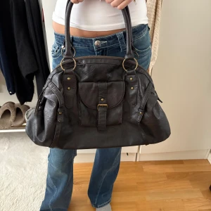 Brun vintage väska - Säljer denna mörkbruna vintage väska köpt secondhand. Står inget märke i den. Bilderna är från förra ägaren!