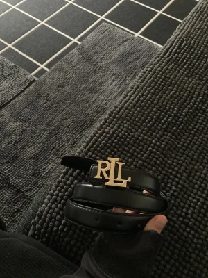 Svart skärp  - Bältet tillhör INTE ett märke Snyggt svart skärp med ett stilrent guldigt-spänne. Perfekt accessoar för att lyfta din outfit med en lyxig touch. 110cm