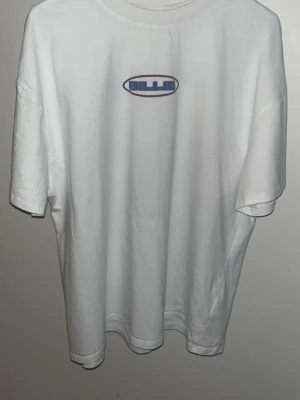 Billie Eilish x Bershka vit t-shirt - Vit t-shirt från Billie Eilish x Bershka ifrån den tiden hon hadde konserten i Sverige med tryck fram och bak. Framsidan har ett litet Billie-logotryck, baksidan har stort färgglatt motiv med text och bild. Rund hals och korta ärmar, tillverkad i mjuk bomull. Perfekt för dig som gillar statement-plagg och coola prints.