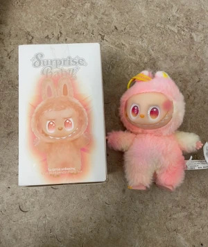 Rosa fluffig väst med kaninöron - Säljer en supergullig rosa fluffig väst med kaninöron från Surprise Baby. Västen har en mjuk och lurvig yta i syntetmaterial och är designad med ljusrosa och vita nyanser. Perfekt för dig som vill sticka ut med en lekfull och söt stil.