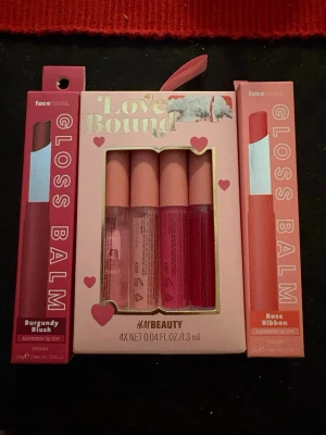 Gloss Balm och Love Bound läppglans - Säljer två Gloss Balm från facefacts i nyanserna Burgundy Blush och Rose Ribbon, båda veganska och med byggbar färg. Dessutom ett Love Bound kit från H&M Beauty med fyra läppglans i olika rosa och röda toner, alla med matt rosa lock.