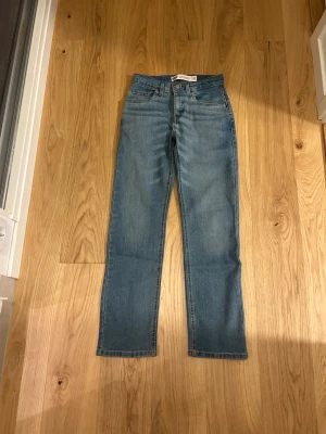 Levi's 514 ljusblå jeans  - Säljer ett par Levi's 514 Performance Straight jeans i ljusblå tvätt. Klassisk femficksmodell med raka ben och normal passform. Jeansen har Levi's patch bak i midjan och röd logotagg på bakfickan. Perfekt för dig som gillar tidlös denimstil.
