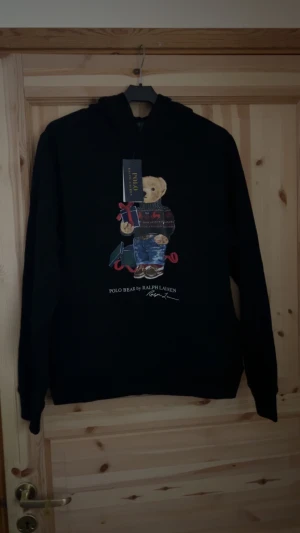 Polo Ralph Lauren bear hoodie  - En väldigt snygg Polo Ralph Lauren bear hoodie helt oanvänd!!! Ända negativt med hoodien. Den är i barn storlek 163-174 cm lång. Men passar även XS storlek.