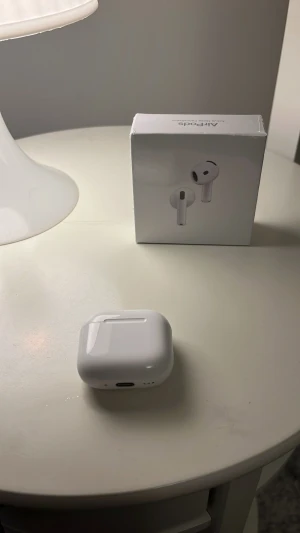 AirPods 4 - Snygga och moderna Apple AirPods 4 med aktiv brusreducering. Levereras med laddningsetui och originalförpackning. Kompatibla med USB-C och Qi-laddning. Produkten ser ut att vara i mycket gott skick utan synligt slitage eller defekter. Perfekt för julklapp och kvitto bevis finns
