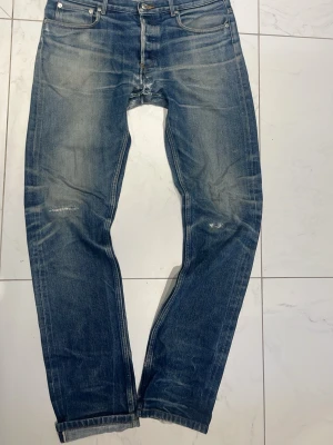 A.P.C. Petit Standard blå jeans salvage - Blå jeans från A.P.C. Petit Standard med klassisk femficksdesign och raka ben. Jeansen har slitningar och ljusare tvättade partier för en cool, använd look. Materialet är robust denim i bomull och passformen är straight. Perfekt för dig som gillar en avslappnad stil.
