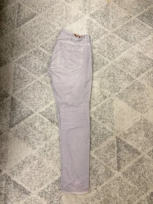 Ljusgråa Dondup George - Säljer ett par ljuslila jeans från George i storlek 32. Oanvända. Säljs för lägre pris då D symbolen gick av. Symbolen följer med i packetet så ni själva kan sätta fast den