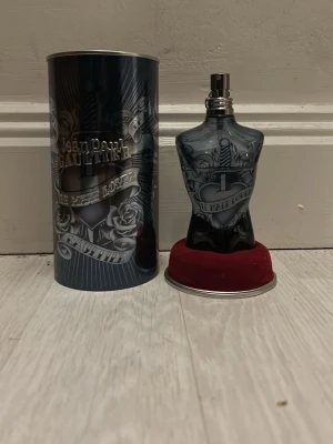 Jean Paul Gaultier Le Male Lover - Unik och cool design med tatueringsinspirerade detaljer. Perfekt för dig som vill sticka ut och addera en edgy touch till din stil. Flaskan är formad som en torso och levereras med originalförpackning.