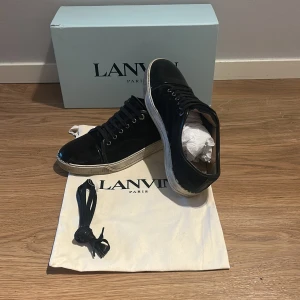 Svarta sneakers från Lanvin - Stiliga sneakers från Lanvin med en glansig tå Långst fram av skon. Lite små skador på sulan annars är det jätte bra skick.