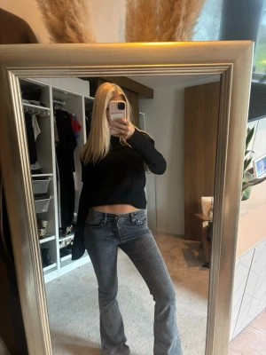 Grå bootcut jeans med låg midja - Säljer ett par grå jeans med snygg bootcut och låg midja. Jeansen har klassisk femficksdesign och är gjorda i mjukt denim-material. Passformen är slim upptill och blir vidare nedtill, vilket ger en schysst siluett. Perfekta för dig som gillar en cool och avslappnad stil.