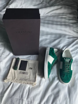 Valentino Flycrews Emerald Green - ”Kom med prisförslag om du är intresserad!💎” Valentino Flycrews - Färg: Emerald Green - Skick: 9,5/10 - Storlek: 41 passar upp till 42 - Defekter: Inga förutom att det fattas två nitar, en på varje sko - Tillbehör: Original box, två dustbags, extra skosnören, Valentino kuvert och 10 reserv nitar (extra nitarna är ej original) - Nypris: 7499 kr - Hör gärna av dig vid frågor / AR Resell ⚜️
