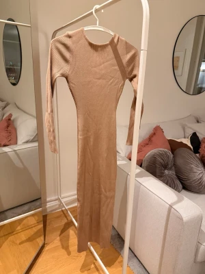 Ribbad beige långklänning  - Supersnygg ribbad långklänning i beige från Missäy i Göteborg, aldrig använd. Passar mig bra som har storlek Xs, men eftersom den är stretchig passar den även s/m
