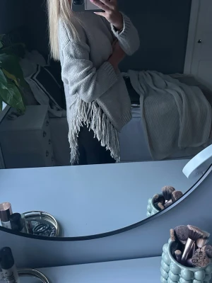 Beige stickad tröja med fransar - Beige stickad tröja med fransar på sidorna