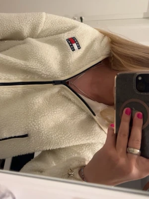 Vit teddyjacka  - Säljer en supermjuk och fluffig vit teddyjacka från Tommy Hilfiger. Funkar både att ha som jacka, tröja. 