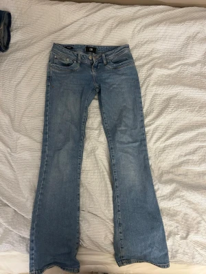 LTB ljusblå bootcut jeans 26/30 - Säljer ett par ljusblå bootcut jeans från LTB i modellen 5145. De har låg midja och klassisk femficksdesign. Jeansen är tillverkade i jeansmaterial och har en snygg bootcut passform. Lite slitning längst ner