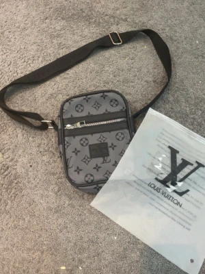  Grå axel väska - Grå axel väska med svart mönster runt om 