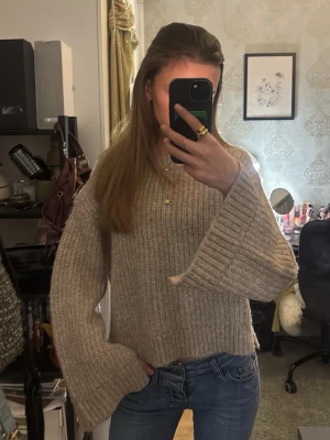 Beige stickad tröja med vida ärmar m öppning - Supermysig beige stickad tröja med breda, långa ärmar och grov ribbstickning🥰