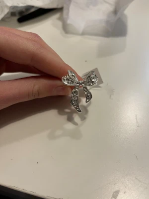 Söt silverfärgad rosettring från Glitter - Rosett ring från glitter. Aldrig använd och kvitto finns. 19mm