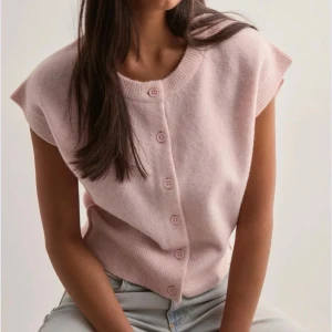 Ljusrosa ärmlös kofta - Supersöt ljusrosa ärmlös kofta från Nelly. Koftan har knappar framtill i matchande färg och är gjord i mjukt stickat material🩷🩷🩷🩷 