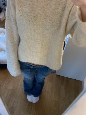 Beige stickad tröja från Pieces - Mysig beige stickad tröja från Pieces i storlek XS. Tröjan har en loose passform och långa ärmar, perfekt för att chilla eller hänga med kompisar. Materialet är fluffigt och ger en skön känsla mot huden. Enkel att matcha med jeans eller andra favoritplagg.