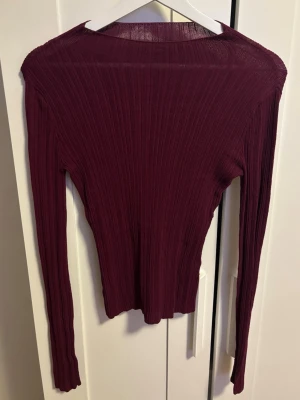 Vinröd ribbad topp från BikBok - Säljer en vinröd långärmad topp från BikBok i storlek S. Toppen är ribbad och har en tight passform med stretchigt material.