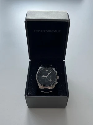 Emporio Armani klocka - Emporio Armani klocka | 43mm i diametern | silvrig med svart ur  | skick 9/10 liten liten spricka längst upp på klockans glas | pris går att diskuteras | hör av dig vid frågor och funderingar!