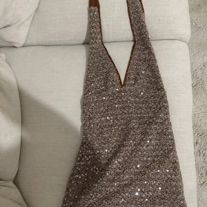 Brun glittrig klänning - Brun glittrig klänning med v ringad 