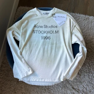  Acne Studios long sleve - En trendig vit longsleve från Acne Studio i storlek S!✌️Tröjan är köpt på Nk för 3800kr och är nästan aldrig andvänd! Skick 9/10. Passar dig mellan 170-183 beroende på hur du vill att den sitter. Hör av er om minsta frågor!