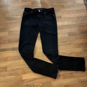 Mörkblå jeans från Jacob Cohen - Snygga mörkblå jeans från Jacob Cohen med klassisk femficksdesign och diskreta kontrastsömmar. Jeansen har raka ben och silverfärgade detaljer vid fickorna samt logotyp på bakfickan och bakre midjan. Tillverkade i mjukt denimtyg för en bekväm känsla.