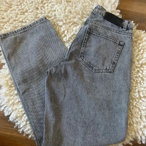 Grå jeans från Grunt, storlek 26 - Snygga grå jeans från Grunt i modellen Harmon Ash Grey. Klassisk femficksdesign, raka ben och normal passform. Jeansen är tillverkade i bomull och har en cool, tvättad look som passar perfekt till streetwear-stilen.