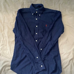 Mörkblå skjorta från Ralph Lauren - Mörkblå skjorta från Ralph Lauren i storlek S. Fint skick till ett bra pris. Nypris: 1995kr. Mitt pris: 299kr                  Vid frågor eller funderingar, tveka inte att höra av dig.