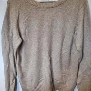 Beige stickad tröja från VILA - Säljer en enkel och snygg beige stickad tröja från VILA i storlek M. Tröjan har rund halsringning, ribbade muddar och lång ärm. Perfekt för dig som gillar neutrala färger och vill ha en klassisk look.