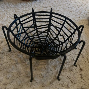 Plastskål med spindelnätsdesign - Unik plastskål med spindelnätsmönster och ben, perfekt som dekoration eller förvaring. Svart pulverlackerad finish, stabil konstruktion och i mycket gott skick utan synligt slitage. Passar utmärkt till Halloween eller som samtalsstartare i hemmet.