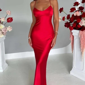 Röd maxiklänning med öppen rygg - Säljer en röd, figurnära långklänning i satin med smala axelband och snygg snörning i ryggen. Hade denna på min bal, de 2 sista bilder är mina egna bilder. Köpte denna på Babyboo för ca 900/1000kr men med frakt betalade jag 1300kr! Användes endast på min bal och den är tvättad efter det, mycket fint skick på klänningen. Har även sytt upp den hos sömmerska. Klänningen heter ”Malika Maxi Dress” på hemsidan❤️