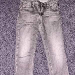 Replay Wallys grå jeans, straight fit - Snygga grå jeans från Replay, modell Wallys, med klassisk femficksdesign och raka ben. Jeansen har coola detaljer på bakfickorna och kontrastsömmar. Passar dig som gillar en avslappnad och stilren look.