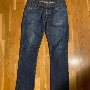 Nudie Jeans Grim Tim Dry Dirt 34/32 - Säljer ett par mörkblå Nudie Jeans Grim Tim Dry Dirt. Bra kondition och använda fåtal gånger av mig (köpta begangnat). Ifall mer frågor eller bilder så är det bara att skriva!