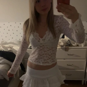 Vit spetsblus med v-ringning - Säljer en vit blus i spets med v-ringad hals och långa ärmar. Blusen är figurnära och har ett transparent, blommigt spetsmönster som ger en romantisk vibe. Perfekt att styla med både kjol och jeans för en trendig look. Från Vero Moda, använd några enstaka gånger💕orginalpris 429.90kr