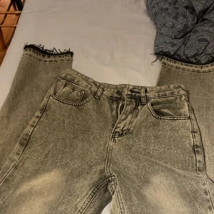 Grå bootcut jeans med råa kanter - Säljer ett par gråa fleared jeans med en riktigt snygg grå och svart combo bra för dig som gillar lite mer baggy än slim fit Jeans.